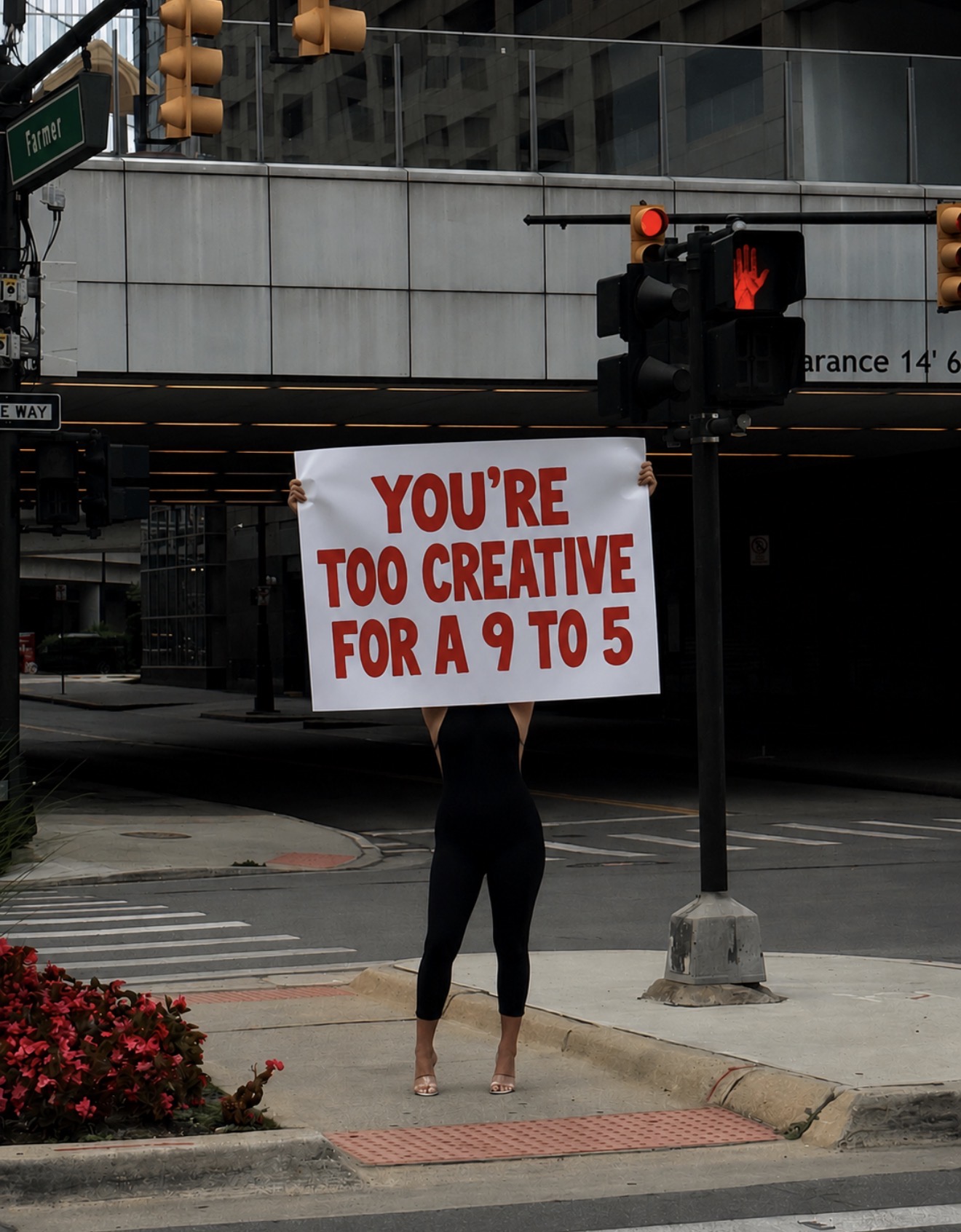 Woman holding a sign that says you're too creative for a 9 to 5